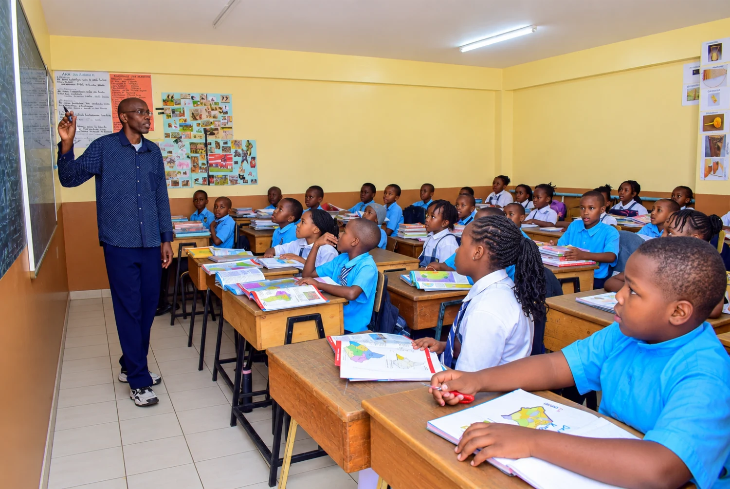 Upper Primary pupils following a lesson with their atlases at St. Christopher's