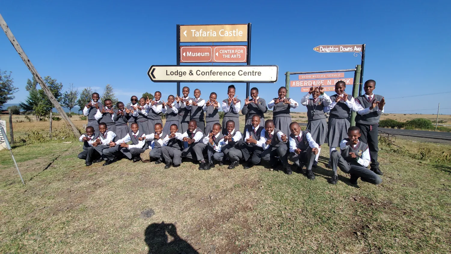 St. Christopher's students at the Tafaria Castle and Aberdare National Park signposts on an educational trip